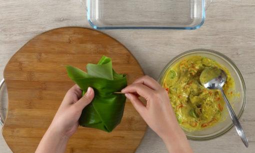 garang asem ayam dibungkus daun pisang, ditambah kemangi, dan disematkan oleh tusuk gigi