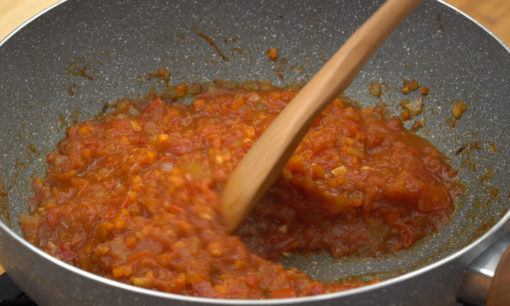 Memasak tomat sebagai satu langkah dalam cara membuat saus tomat.