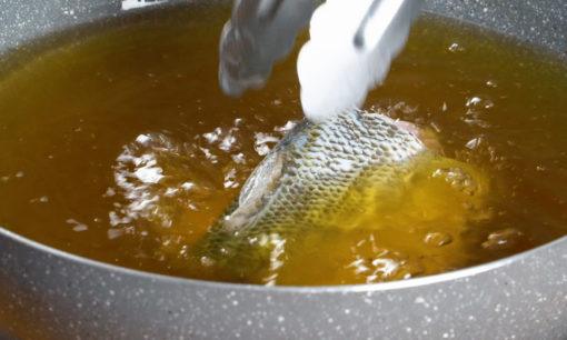 Menggoreng ikan bandeng.