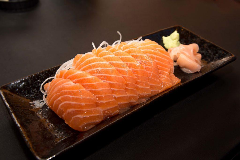 Sepiring sashimi salmon sebagai asupan makanan khas di restoran Jepang.