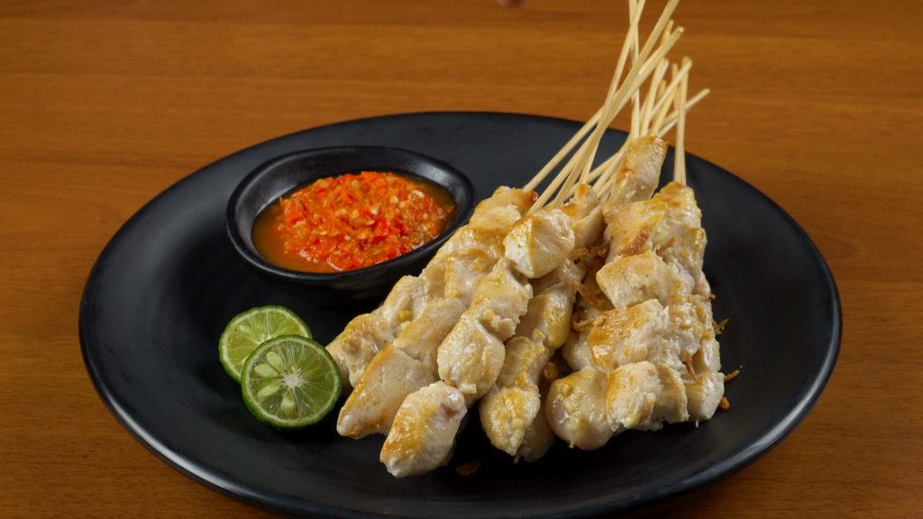 Sate taichan tersaji di atas piring hitam.