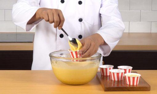 Menuangkan adonan pada cetakan cara membuat bolu kukus keju.