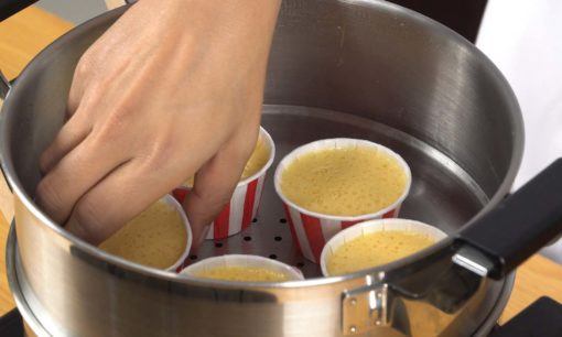 Mengukus bolu sebagai tahap dalam cara membuat bolu kukus keju.