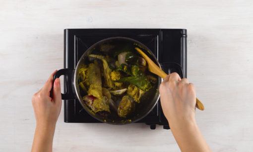 Memasak ayam untuk opor telur kuning.