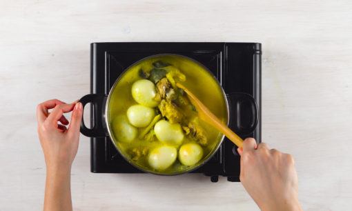 Memasak santan untuk opor telur kuning.