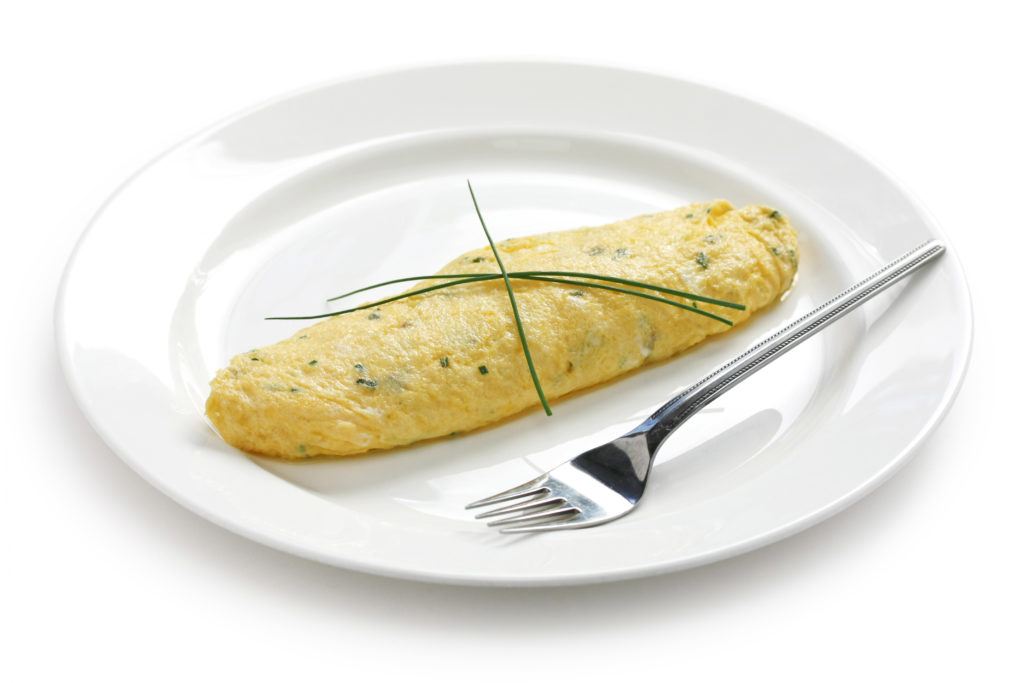 Omelet Prancis tersaji di atas piring putih.