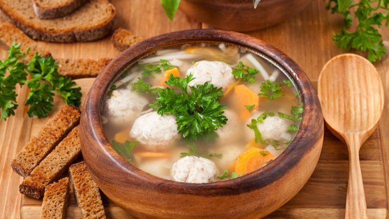Sup tahu bakso ikan hangat disajikan di dalam mangkuk kayu.