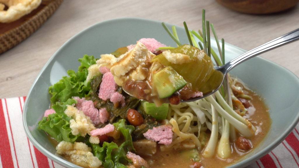 Asinan sayur Betawi, makanan khas Jakarta, tengah disendoki dan siap dinikmati.