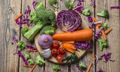 Satu talenan bulat kayu berisi bahan tumisan sayur berupa potongan wortel, kol ungu, tomat, bawang merah besar, dan brokoli.