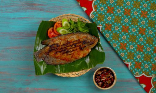 Ikan gurame bakar tersaji dengan lalapan dan sambal kecap.