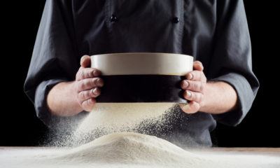 Seorang chef tengah menyaring tepung terigu untuk membuat kue menggunakan sieve, sebuah nama peralatan dapur yang unik.