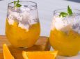 Dua gelas es kelapa muda dengan jelly jeruk diletakkan di atas talenan.