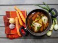 Menu buka puasa praktis berupa sepanci sup ayam dengan bahan-bahan masakan di sekitarnya.