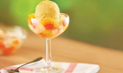 Segelas tinggi es krim buah berisi potongan buah dan nata de coco serta es krim yang dinamakan Fresh Mango Frutilicious.