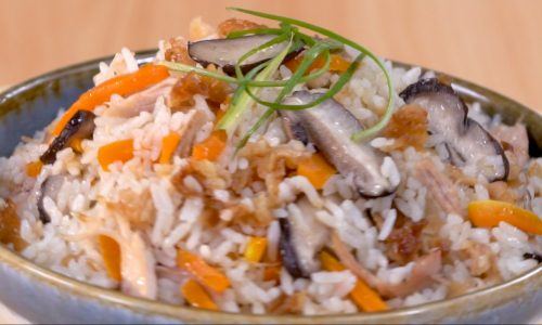 Hasil masak resep nasi ayam rice cooker tersaji dalam mangkuk.