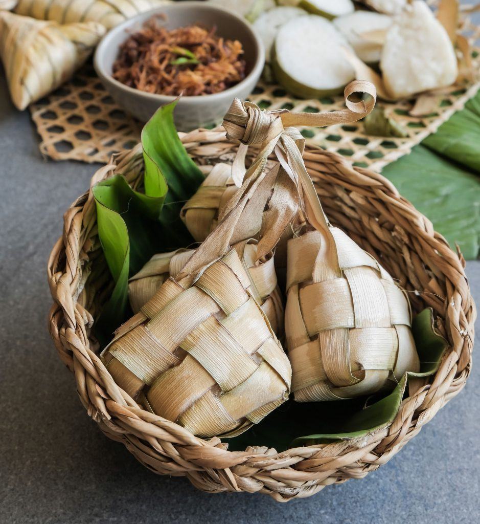 Tiga ketupat matang di dalam piring rotan.