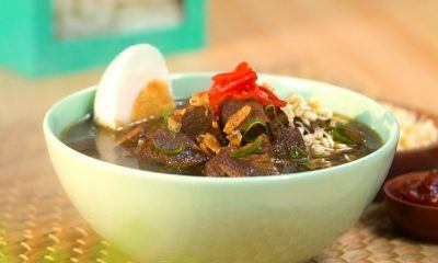 Hasil masak makanan khas Malang resep rawon tersaji dalam mangkuk, hangat lengkap dengan telur asin.