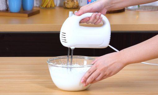 Mengocok krim hingga kaku dalam mangkuk menggunakan mixer.