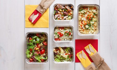 Empat kotak jajan sehat berisi makanan sehat dan sendok garpu kayu