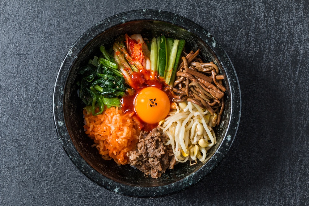 Dolsot bibimbap, makanan khas Korea Selatan dengan topping macam-macam sayuran dan telur disajikan dalam mangkuk batu.