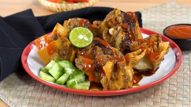 Sepiring hasil masak resep batagor Bandung, makanan khas Bandung, disajikan bersama jeruk nipis, bumbu kacang, dan sambal.