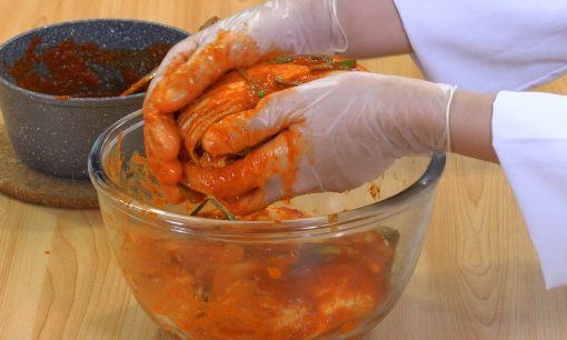 Mencampur bumbu halus dengan kimchi.