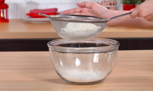 Mengayak tepung terigu untuk resep nastar.