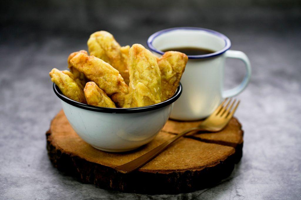 Pisang goreng kinca disajikan bersama kopi.