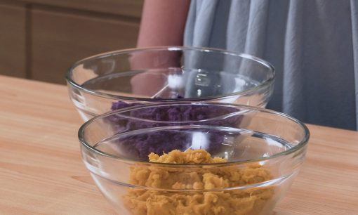 Ubi ungu dan oranye dihaluskan dan diletakkan dalam mangkuk.