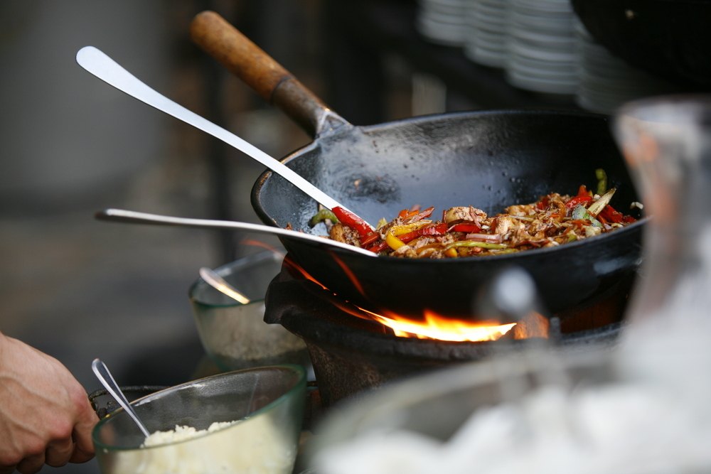 Sebuah wok tengah dipakai untuk memasak.