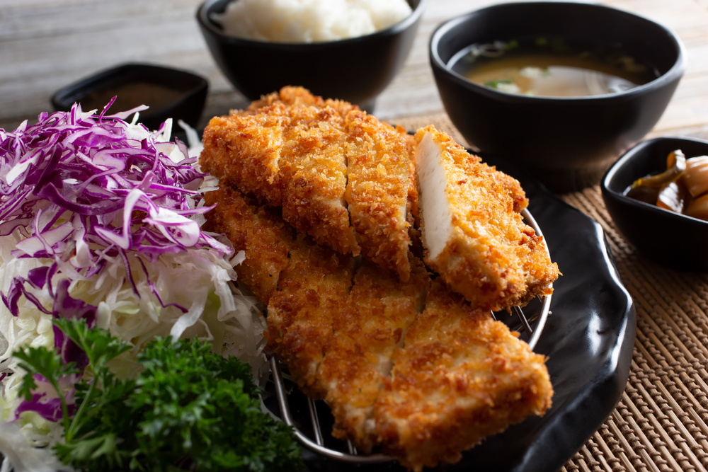 Piring berisi tahu katsu, nasi, dan saus kari.