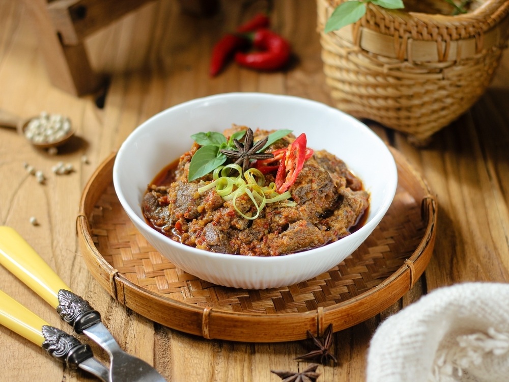 Mangkuk berisi oseng daging kambing bumbu rica.