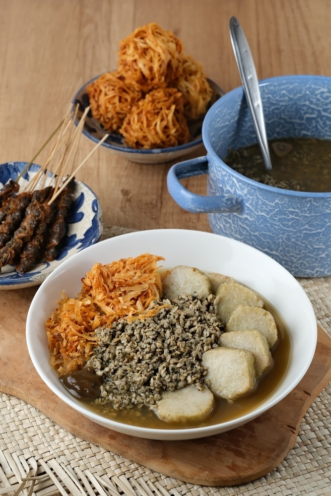 Lontong kupang sebagai makanan khas Jawa Timur disajikan dengan sate kerang dan lentho.