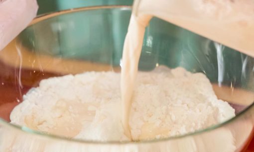 Mencampur susu dengan tepung untuk resep bakpao