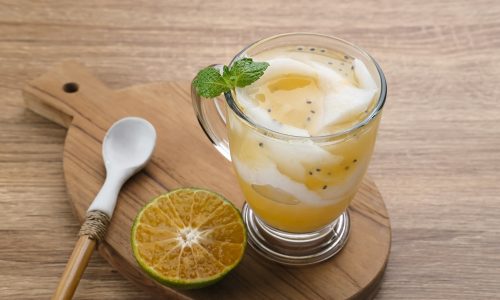 Hasil cara membuat es kopyor jeruk disajikan dalam gelas.