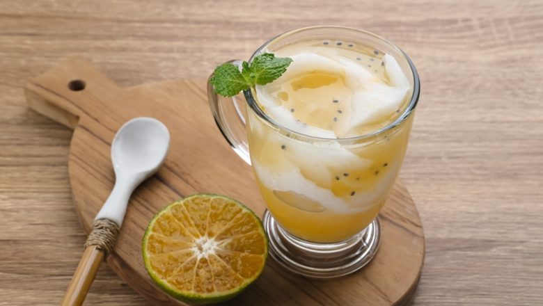 Hasil cara membuat es kopyor jeruk disajikan dalam gelas.