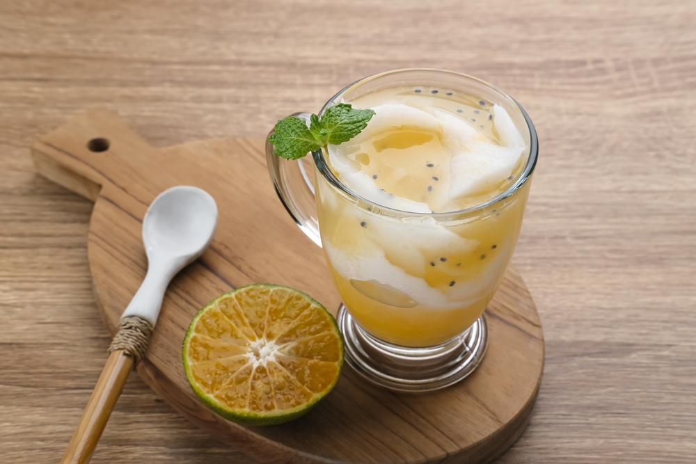 Hasil cara membuat es kopyor jeruk disajikan dalam gelas untuk takjil buka puasa.