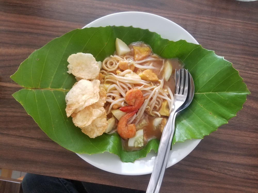 Seporsi mie Belitung disajikan di atas piring dan daun.