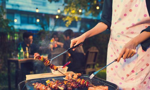 Seorang wanita sedang memasak menu bakar bakar tahun baru.