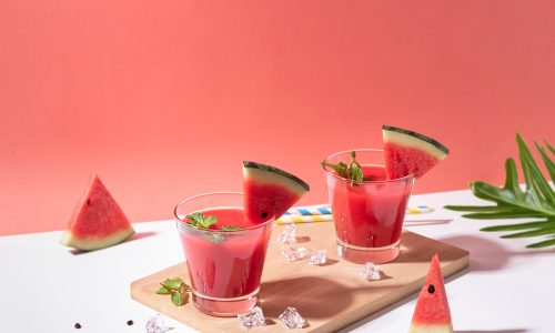 Dua gelas olahan resep es semangka India disajikan di atas talenan.