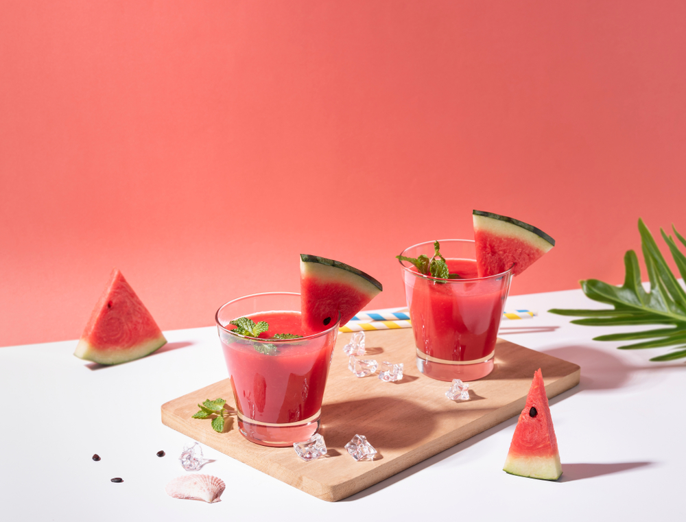 Dua gelas olahan resep es semangka India disajikan di atas talenan.