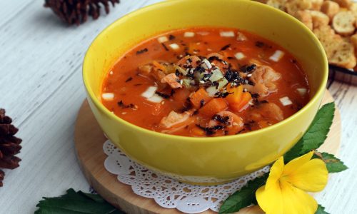 Mangkuk berisikan olahan resep sup merah dengan topping sayuran.