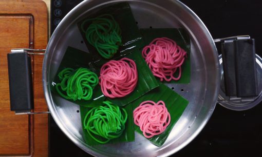 proses mengukus kue putu mayang berwarna pink dan hijau di dalam dandang
