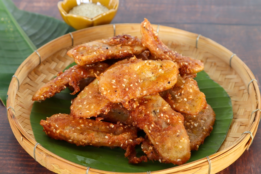 Pisang goreng crispy dalam wadah piring bambu.