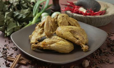 Ayam bumbu kuning dalam piring persegi.