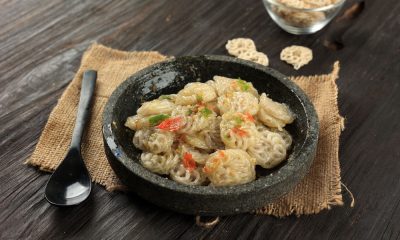 Seblak cobek pedas dalam cobek berwarna gelap.