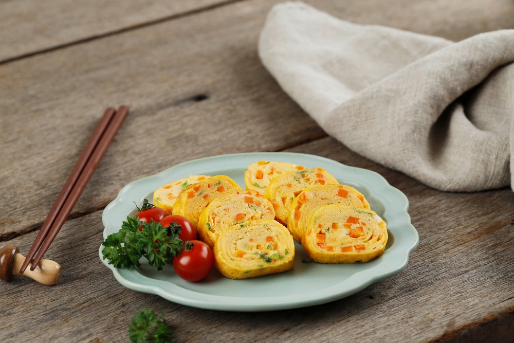 Tamagoyaki isi telur dengan tomat ceri dan parsley.