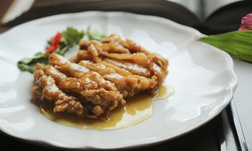 Hidangan ayam nanking dengan sausnya di atas piring putih. (Foto: Shutterstock)